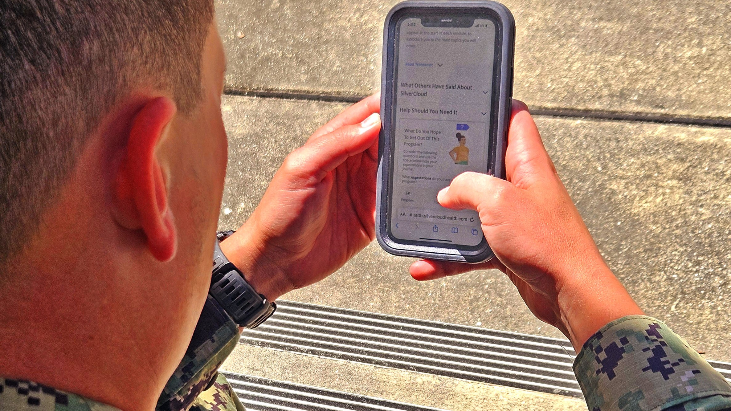Naval service member reads about Silvercloud on his smartphone