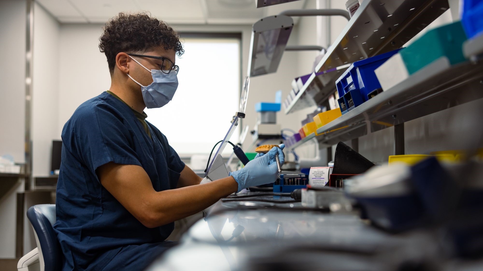 tech works on molding of teeth in a lab.