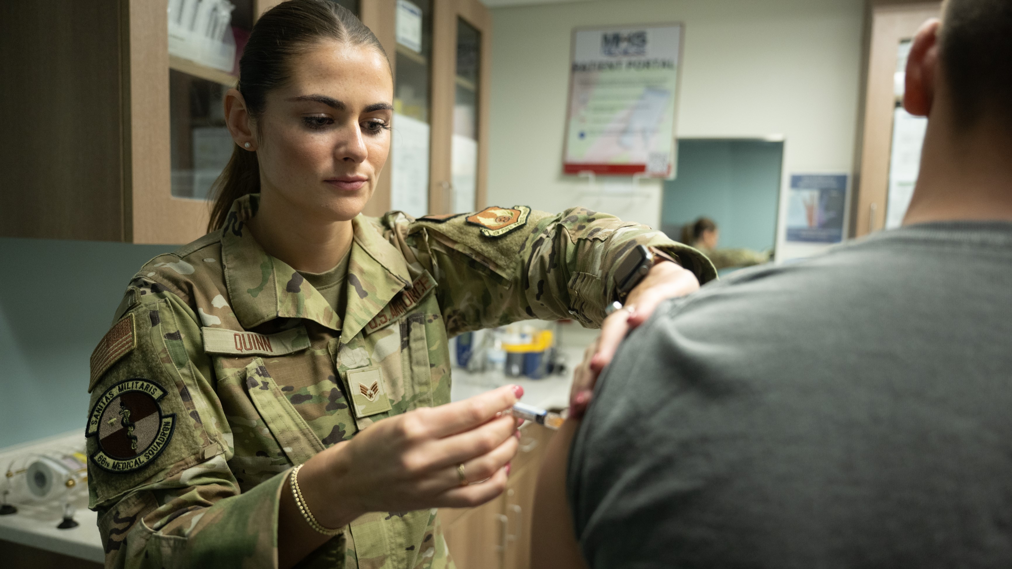 Air Force officer gives service member a shot