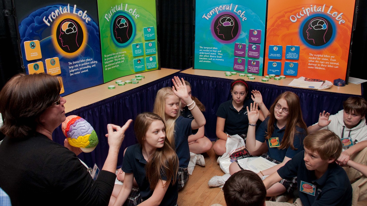 A brain scientist from the National Institute of Neurological Disorders and Stroke quizzes students about regions of the brain as they experience the Brain Lobe-oratoriumTM during the National Museum of Health and Medicine’s Brain Awareness Week.