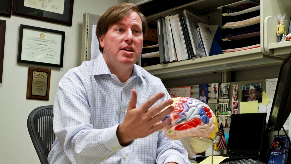 Douglas B. Cooper, a clinical neuropsychologist for the San Antonio Military Medical Center’s Traumatic Brain Injury Service, explains how different areas of the brain are affected by brain injuries during an interview at the center in San Antonio. Cooper is the team lead on the Study of Cognitive Rehabilitation Effectiveness, dubbed the SCORE trial, which is examining cognitive rehabilitation therapy’s value as a treatment for service members with mild TBI. (DOD photo by Linda Hosek)