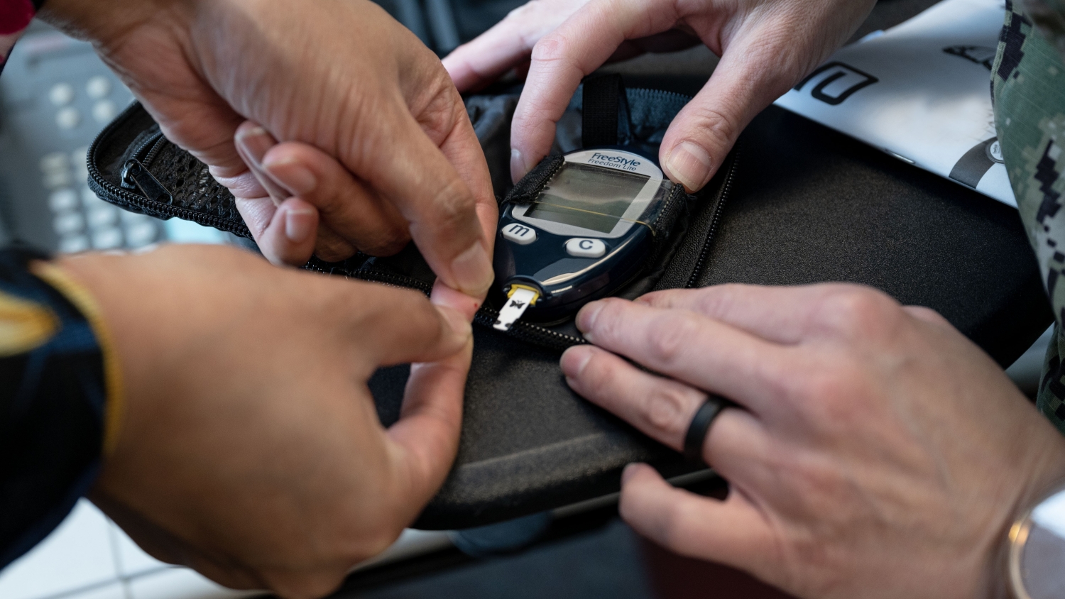 Doctor and patient checking blood sugar level on small device