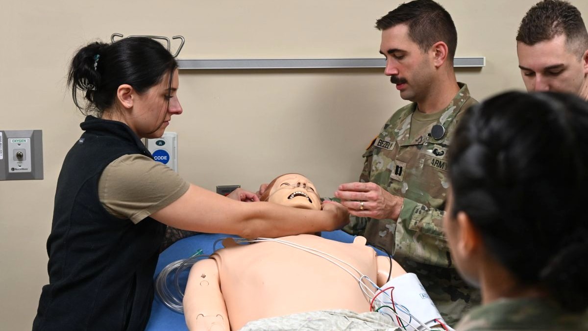 Photo By Frank Minnie | Capt. Demetria Miller (left) and Capt. Collin Bezely (right), emergency medicine residents at Carl R. Darnall Army Medical Center, work with fellow residents to assess a simulated patient and provide oxygen during a medical training scenario at the CRDAMC Medical Simulation Center.