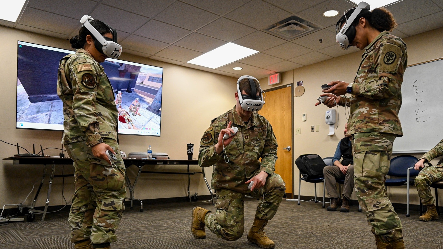 (Left to right) U.S. Air Force Airman First Class Adriana Jackson, 28th Operations Support Squadron all source intelligence analyst, Capt. Ryley McCarthy, 28th Operations Support Squadron chief of combat intelligence cell and U.S. Army Sgt. Melody Irwin, 1st Medical Brigade animal care technician, perform tactical combat casualty care training using virtual reality at Ellsworth Air Force Base, S.D., Jan. 30, 2025. Ellsworth Airmen had the opportunity to collaborate and work as a team utilizing a VR training module with multiplayer functionality. (U.S. Air Force photo by Senior Airman Dylan Maher)