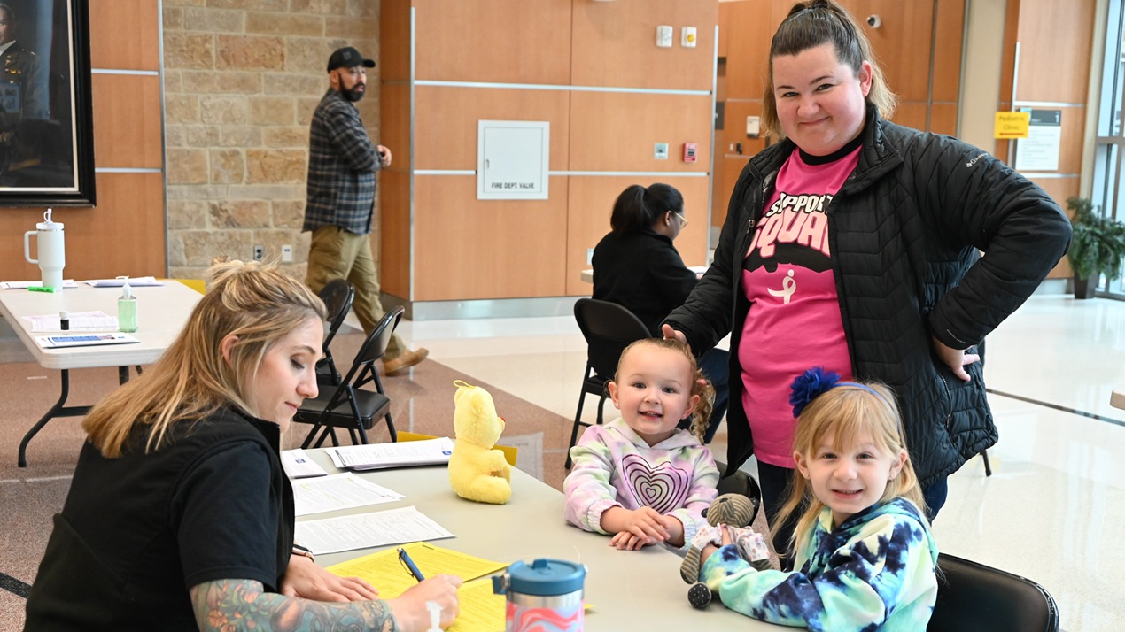 Heather Deckard, and daughters Abigail and Madison, check-in with 1st Lt. Jacqueline Hoppman, Army public health nurse, Carl R. Darnall Army Medical Center to receive vaccinations during the annual CRDAMC flu and COVID-19 event at the hospital.