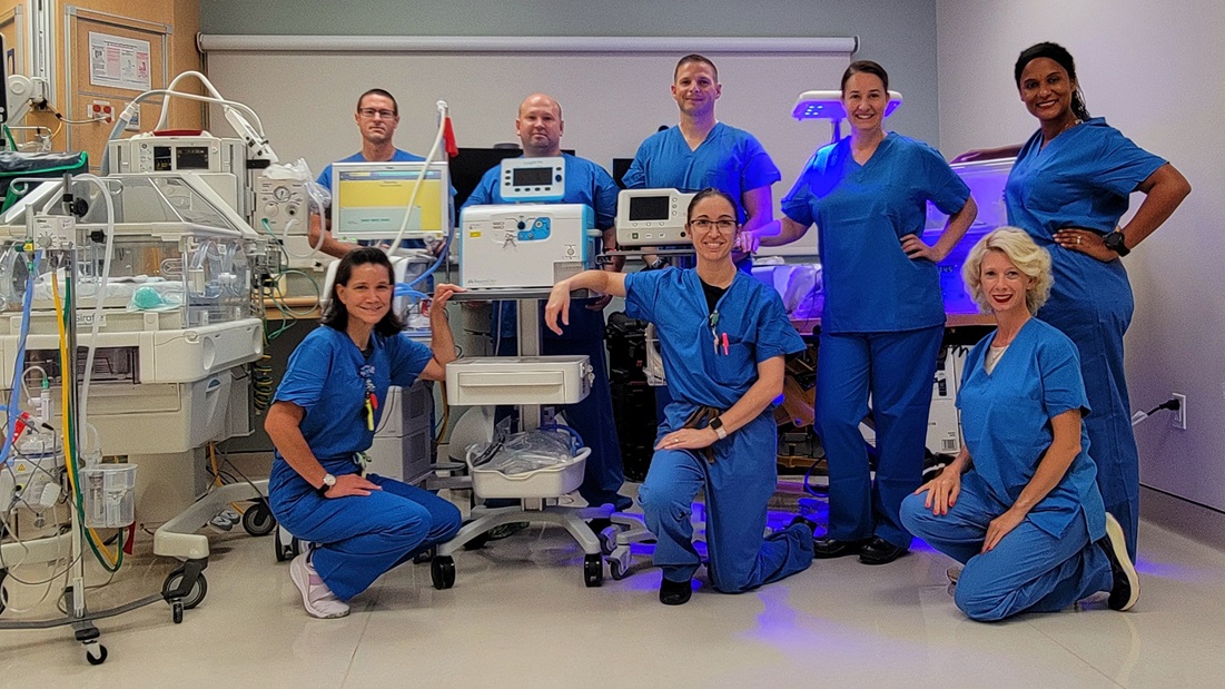 U.S. Naval Hospital Guam’s tri-service, multi-disciplinary Neonatal Stabilization and Transportation (NeST) team poses for a group photo at the hospital, Dec. 23, 2024. From left to right (back row): Army Sgt. Kristopher Allen, respiratory therapist; Army Staff Sgt. Matthew Feathers, respiratory therapist; Army Maj. Bryan Williams, neonatologist; Navy Cmdr. Laura Boerste, neonatal intensive care unit (NICU) nurse; Air Force Capt. Bianca Centeno, NICU nurse; (front row) Navy Lt. Cmdr. Randi Acheson, NICU nurse; Navy Cmdr. Desirae Pierce, NeST steering committee chair and neonatal nurse practitioner; Michelle Wilt, NICU nurse.