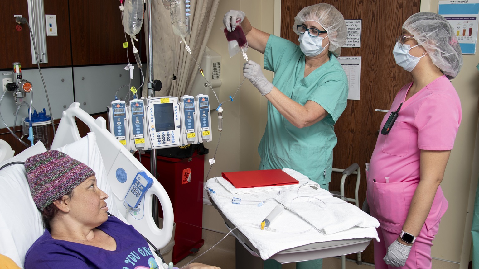 Audrey Hawes, registered nurse, and Josephine Valdez, registered nurse, administer stem cells during patient Roniesha Blaylock’s procedure at Brooke Army Medical Center, Joint Base San Antonio – Fort Sam Houston, Texas, Oct. 8, 2024. Blaylock was diagnosed with aplastic anemia in 2017. Aplastic anemia is a rare but serious blood condition that occurs when your bone marrow cannot make enough new blood cells. (DoD photo by Jason W. Edwards)