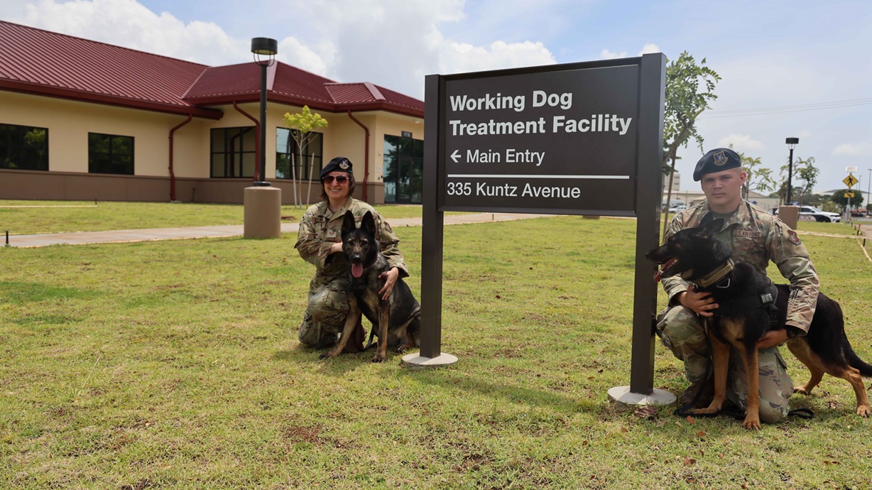 U.S. Air Force military dog handlers pose with their military working dogs in front of the new Veterinary and Military Working Dog Treatment Facility on Joint Base Pearl Harbor-Hickam, Hawaii April 25, 2025. The Naval Facilities Engineering Systems Command (NAVFAC) Hawaii’s FEAD or Facilities Engineering and Acquisition Division Team and contractors completed the construction of the 12,000-square-foot facility which includes five general exam rooms, two isolation rooms, and dedicated rooms for working dogs. The facility will provide full service preventive, diagnostic, surgical and dental care to government-owned animals, food inspection spaces, and preventive and diagnostic services to privately-owned animals of service members on the installation. (U.S. Navy photo by Anna Marie G. Gonzales)