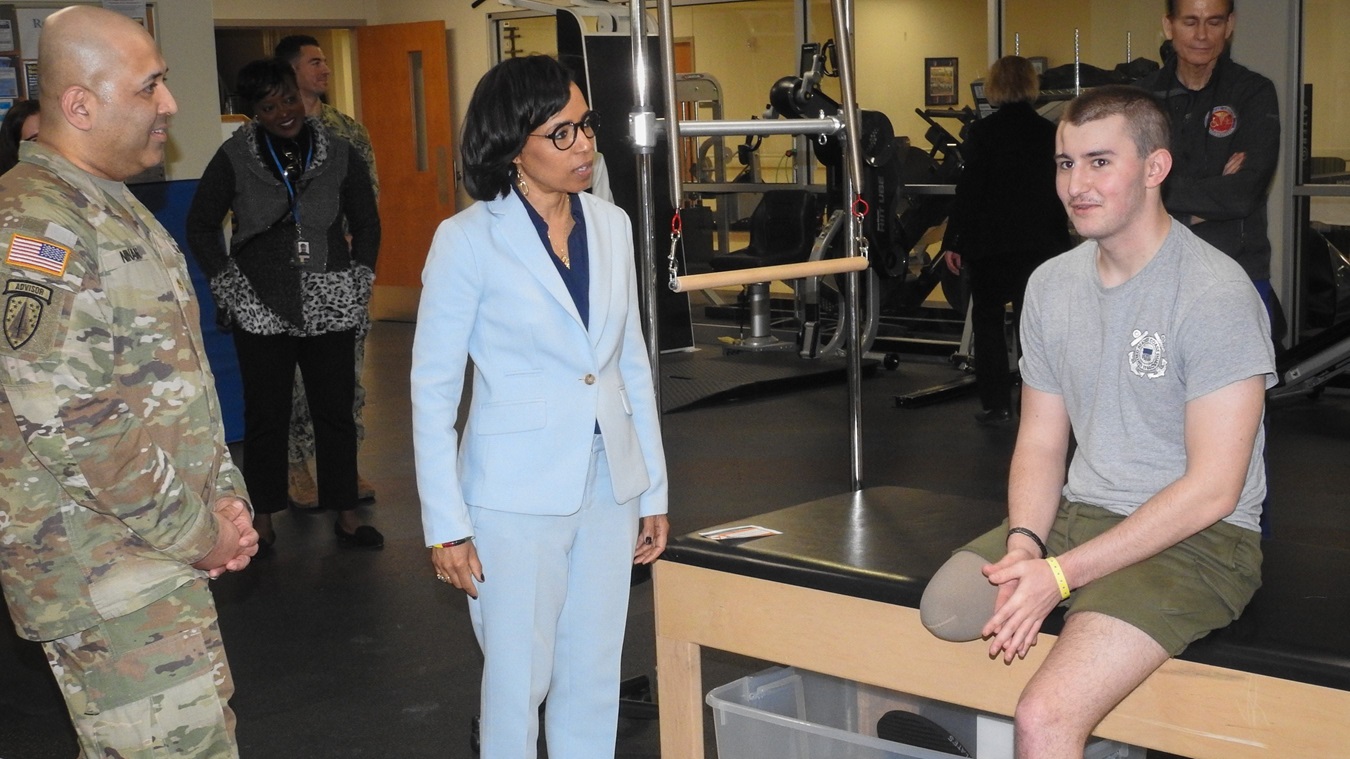 U.S. Senator Angela Alsobrooks of Maryland meets Samuel Kenyon (right), of the U.S. Coast Guard, in the Military Advanced Training Center at Walter Reed, where he and other patients receive physical therapy to help them adapt to their new abilities to improve their overall quality of life. U.S. Army Maj. Ajus Ninan (left), department chief of Walter Reed’s Warrior and Family Coordination Cell, looks on.