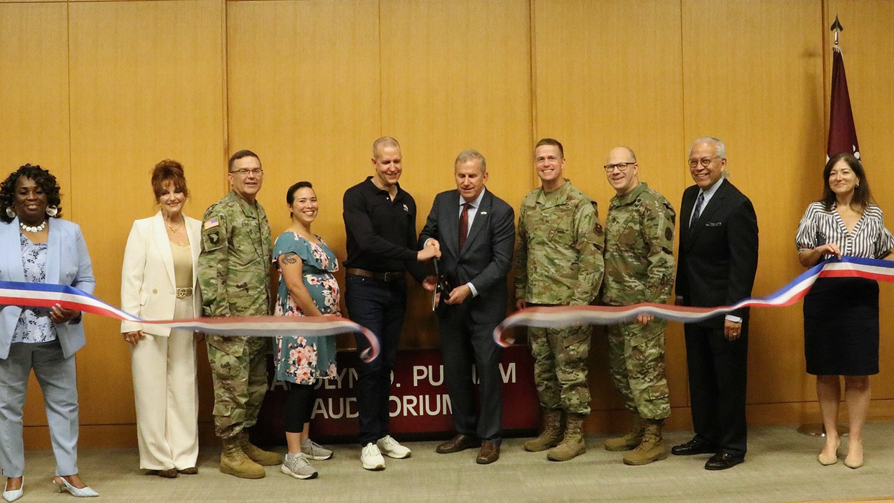 Justin Schmitt (center left), AVP of Corporate Responsibility, USAA, and Retired Rear Adm. Charles F. Williams, Chief of Staff, Armed Services YMCA, cut the ribbon to formally open Brooke Army Medical Center’s Armed Services YMCA Children’s Waiting Room, April 25, 2025, in the Putnam Auditorium. (DoD photo by Robert A. Whetstone)