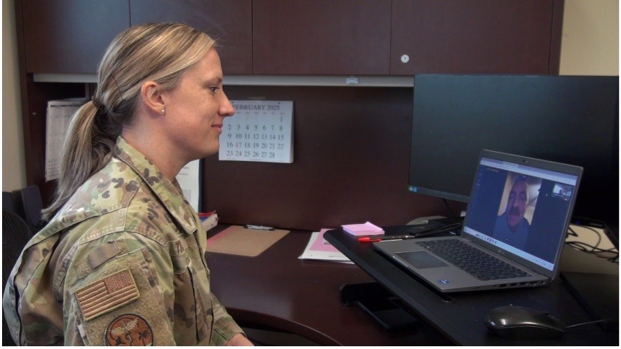 U.S. Air Force Maj. Betsy Trahan meets with a patient virtually using My Military Health Scheduled Virtual Visits. The patient was able to meet with Trahan from home using his mobile phone—citing the convenience of the platform. (Photo by Mike Fisch)