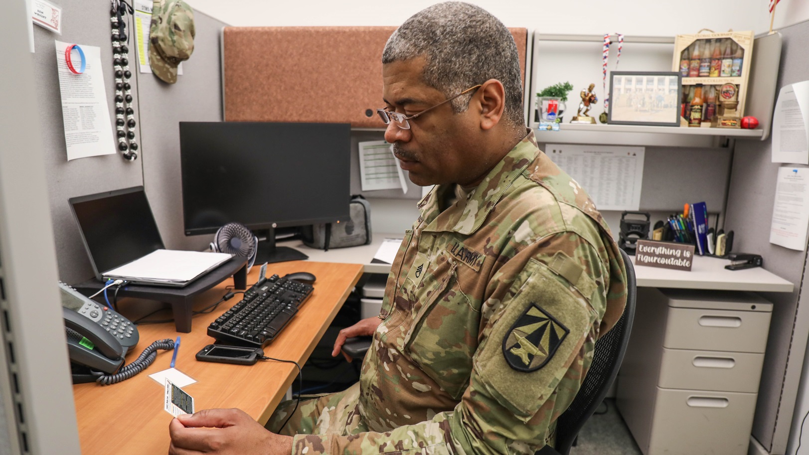 Staff Sgt. Benjamin Wright, NCOIC of Veterinary Pathology, Walter Reed Army Institute of Research, reviews the wallet card before a conversation with one of the service members in his unit.