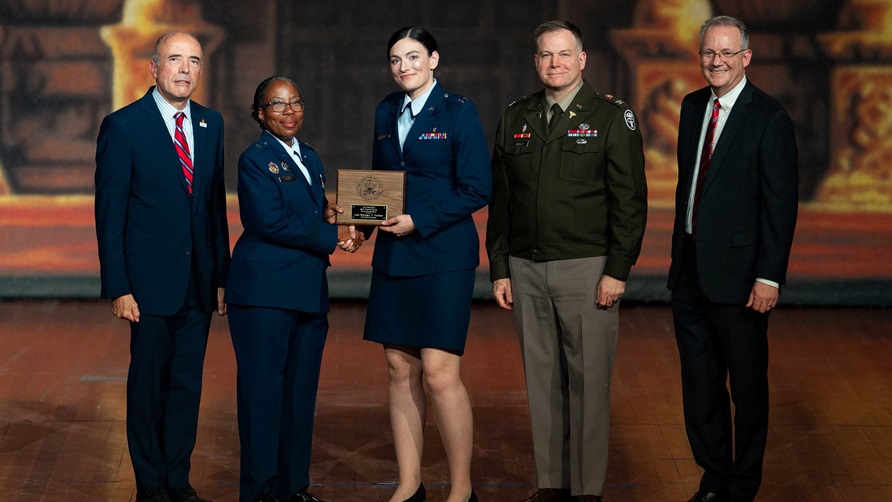 Air Force Brig. Gen. Gwendolyn Foster, 59th Medical Wing commander, presents Air Force Capt. Mikalyn DeFoor, Orthopaedic Surgery resident, the Maj. David Berry Award during the San Antonio Uniformed Services Health Education Consortium graduation ceremony at the Scottish Rite Auditorium, downtown San Antonio, June 6, 2025.