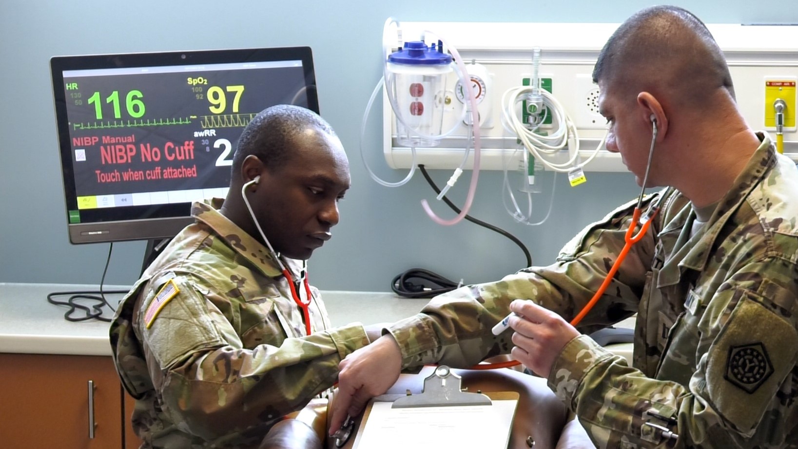 Participants in a medical simulation exercise at the U.S. Army Medical Research Institute of Chemical Defense Vedder Simulation Laboratory assess a simulated nerve agent patient.
