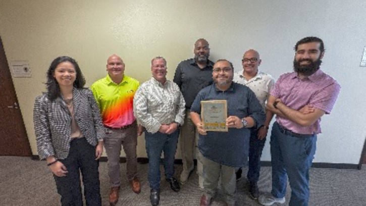 The Defense Health Agency Healthcare Facilities Efficiency, Environmental Compliance & Audit Program team poses with the Practice Greenhealth "System for Change” award plaque after DHA was recognized for working cohesively to set system-wide sustainability goals, track performance data, benchmark, and support intra-organizational learning and implementation within their institutions.