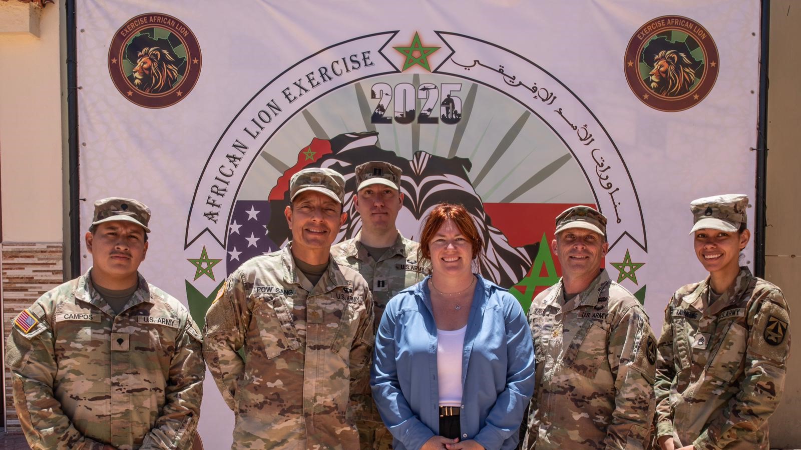 Capt. C. Ian Davis, third from left, deputy chief of the Applied Diagnostics Branch at the U.S. Army Medical Research Institute of Infectious Diseases, poses for a group photo during Exercise African Lion 2025 with Dr. Stephanie Cinkovich, fourth from left, the Defense Health Agency’s military health surveillance activities integrator, and members of the Walter Reed Army Institute of Research biosurveillance team Spc. Jorge Campos, left, Maj. Luis Pow Sang, Maj. John Eads, and Staff Sgt. Brenda Hawkins. USAMRIID and WRAIR teamed up to perform biosurveillance during the multinational training exercise, which took place in Morocco May 7-19, 2025.