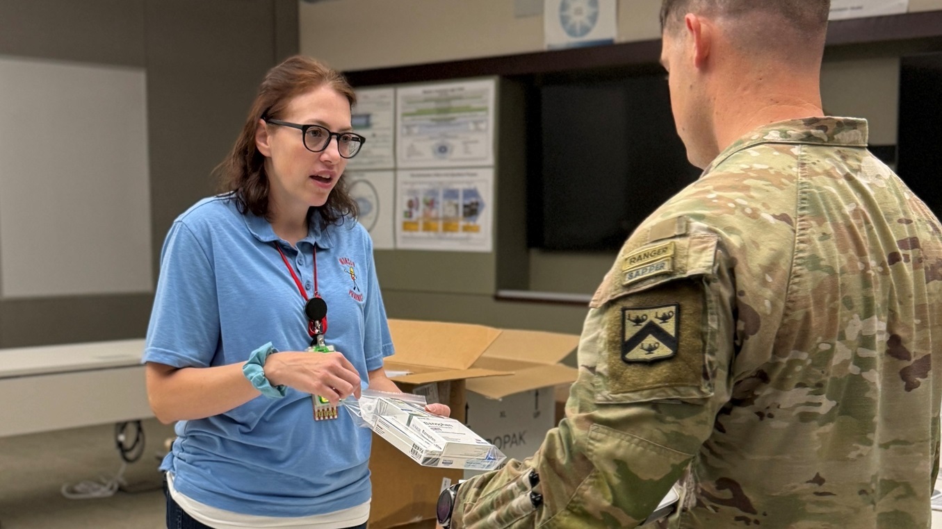 Department of Defense Civilian, Dr. Wendy Harmon, a pharmacist at Munson Army Health Center, Fort Leavenworth Kansas, provides a package of over-the-counter medications to an incoming U.S. Army Command and General Staff College student during medical readiness in-processing July 21.