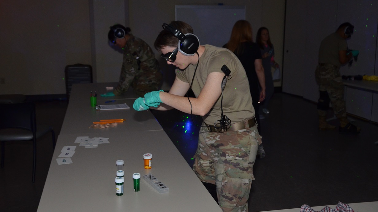 Army Staff Sgt. Brandi Seif, METC operations staff, attempts to perform an individual task under impaired conditions while participating in the Dementia Experience.
