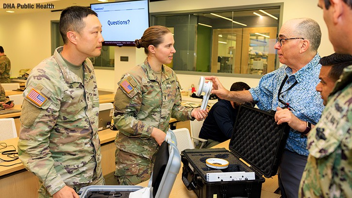 Army Staff Sgt. Paul Chung, noncommissioned officer in charge of the Uniformed Services University Radiation Safety Division in Bethesda, Maryland (left), and Army 1st Lt. Elena Rippeon, a radiation protection officer at Walter Reed National Military Medical Center in Bethesda, Maryland (center), attend a class with Jerry Falo, a health physicist at Defense Centers for Public Health-Aberdeen (right) at the Medical Radiation Safety Officer Course Sept. 16, 2025, at Aberdeen Proving Ground, Maryland. 