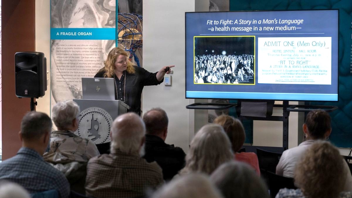 National Museum of Health and Medicine's Chief Archivist, Laura Cutter, highlights archival materials from the NMHM collections to illustrate the different techniques used for education and to influence behavioral choices on the challenges of sexually transmitted diseases during World Wars I and II during a lecture on Aug. 2, 2026 in Silver Spring MD. (National Museum of Health and Medicine photo by Chuck Kennedy)