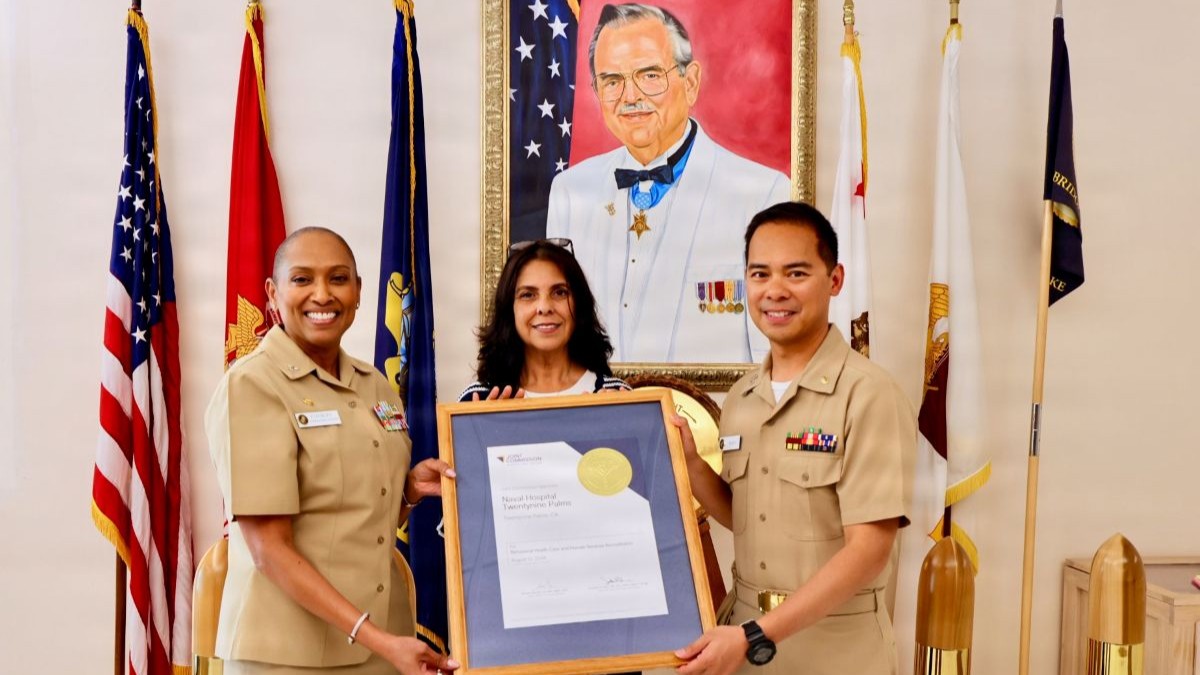 Photo By Christopher Jones | Capt. Janiese Cleckley (left), commanding officer, Navy Medicine Readiness and Training Command Twentynine Palms, and director, Naval Hospital Twentynine Palms, and Teresa Turbyfill (center), quality management department head, present Lt. Ian Mojica, mental health department head, with the department’s Joint Commission reaccreditation certificate at Naval Hospital Twentynine Palms, Calif., Sept. 11, 2026. The mental health department earned reaccreditation with zero findings during its survey by The Joint Commission’s Behavioral Health Care and Human Services Accreditation Program. (U.S. Navy photo by Christopher Jones, NMRTC/NH Twentynine Palms public affairs officer)