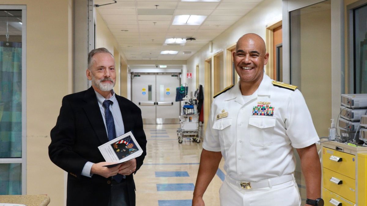 U.S. Navy Rear Adm. Reginald S. Ewing III, right, a native of Churchville, New York and Defense Health Network Pacific Rim director and Naval Medical Forces Pacific commander, poses with Dr. Douglas Carbine, the neonatal intensive care unit’s medical director, during a visit to Naval Medical Center San Diego’s NICU, Sept. 25, 2026. Carbine served as an advisor and mentor to Ewing during his pediatric residency at NMCSD. The visit followed Ewing’s assumption of duties as NMFP commander and DHN-PR director earlier that day. The network oversees nine military hospitals and clinics along the U.S. West Coast and in Guam and Japan, delivering health care to more than 144,000 TRICARE beneficiaries. (Department of War photo by Regena Kowitz/Released)
