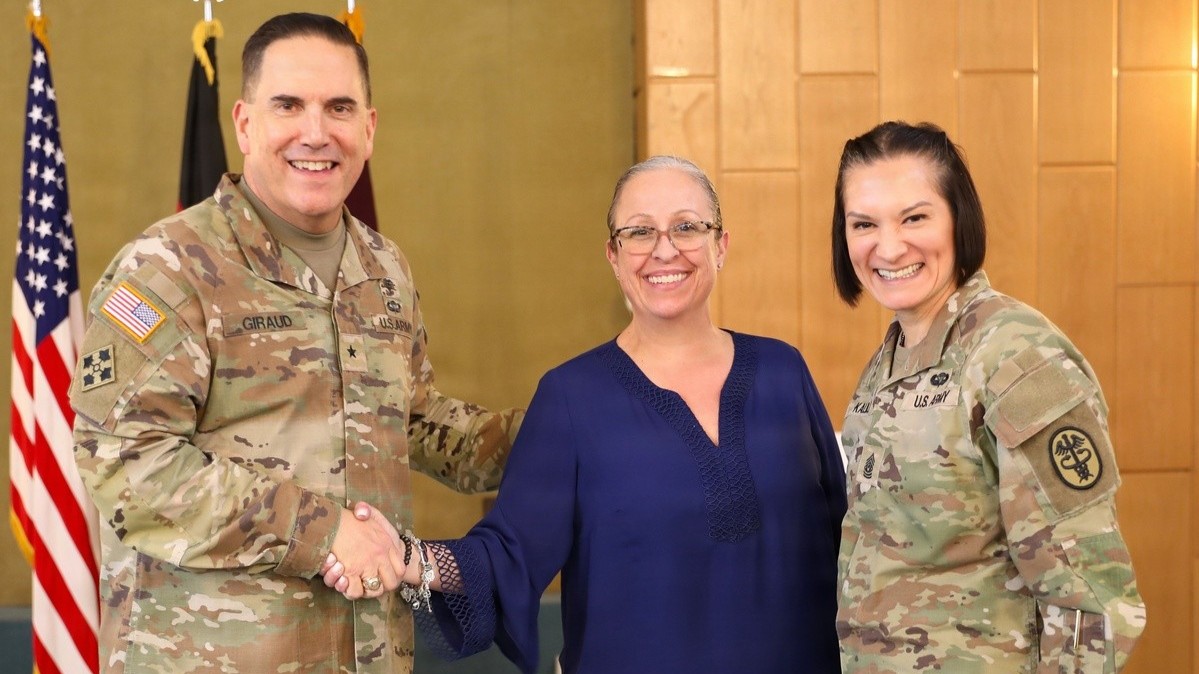 SEMBACH, Germany – The senior leaders of Medical Readiness Command, Europe and Defense Health Network Europe, U.S. Army Brig. Gen. Roger Giraud (left) and Command Sgt. Maj. Kalani Kalili (right), hosted a townhall meeting at the Sembach Chapel Feb. 19 for members of both headquarters. As part of the town hall meeting, awards were presented to several civilian staff members of Defense Health Network Europe in recognition of their commitment to excellence, dedication and achievements. Pictured here is Adriane Carney (center), Defense Health Network Europe Employee of the Quarter - 1st Quarter FY25. (Kirk Frady)