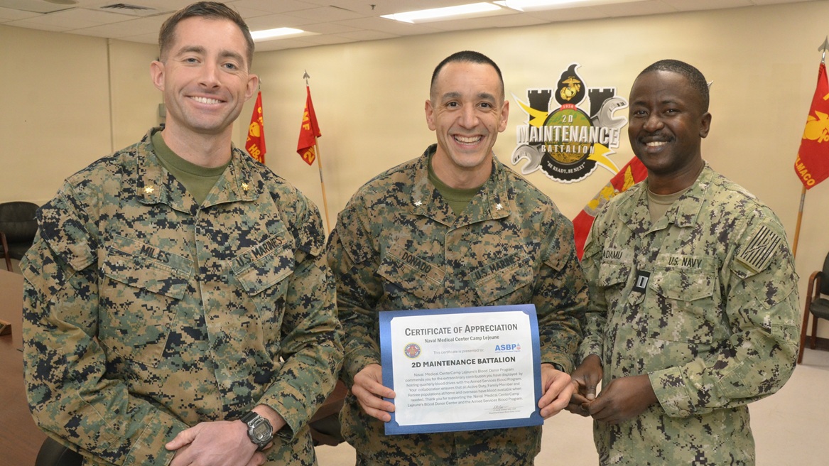 Lt. Najib Adamu, department head for Naval Medical Center Camp Lejeune Blood Services, presents an Armed Services Blood Program Certificate of Appreciation to 2nd Maintenance Battalion Commanding Officer Lt. Col. Joey Donado and Executive Officer Maj. Ben Miles. ASBP is the official blood provider for the United States military, tasked with a vital, life-saving mission: to supply quality blood products to service members and their families across the globe, in times of both peace and war.