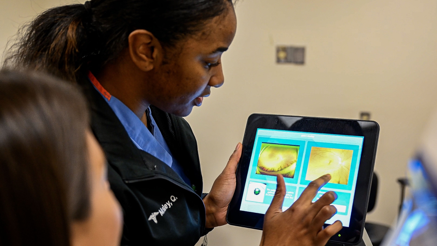 Navy Petty Officer 2nd Class Quinn Mosley shows a patient a scan of their eye