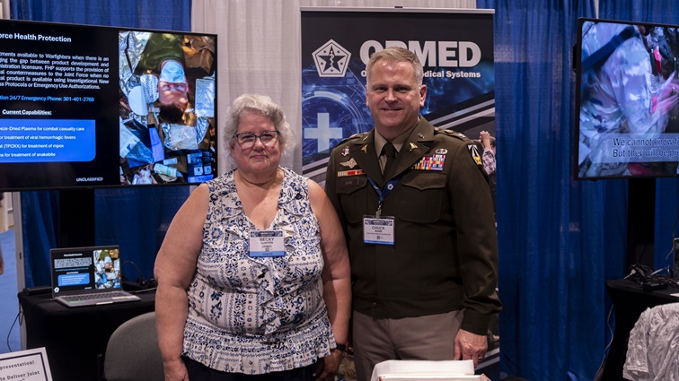 Becky Runyen and U.S. Army Col. Chuck Bane stand for a photo during the Military Health System Research Symposium, Kissimmee, Florida, Aug. 4, 2025.