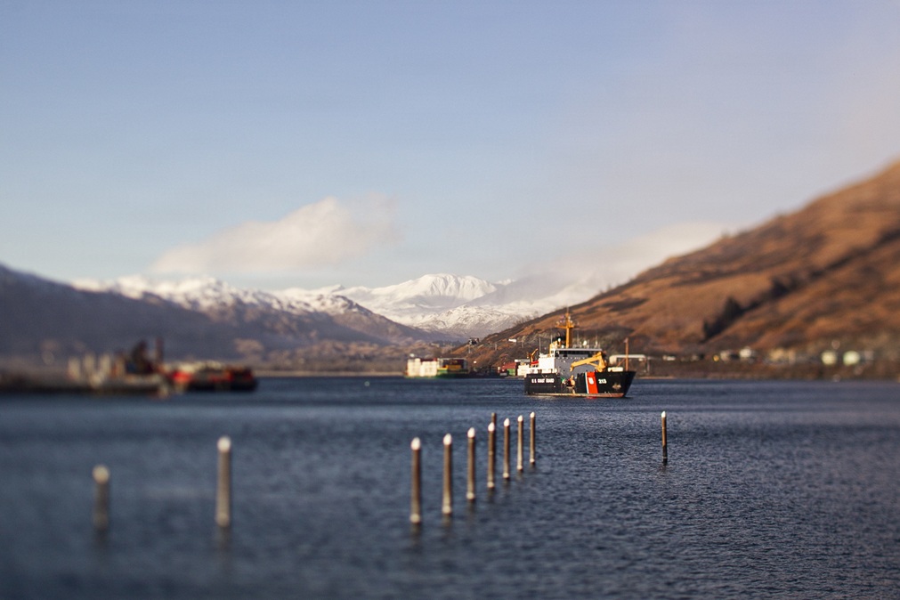 Military medical ship sitting in a harbor, surrounded by hills covered with snow